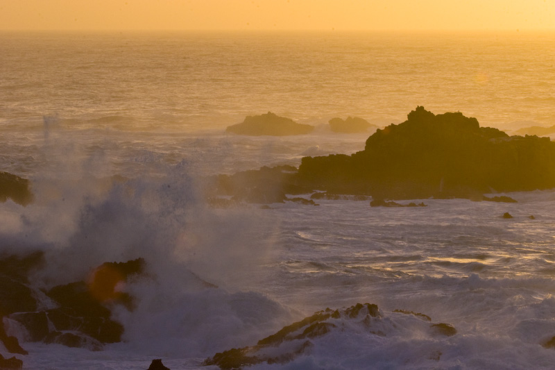 Waves Breaking Over Rocks At Sunset